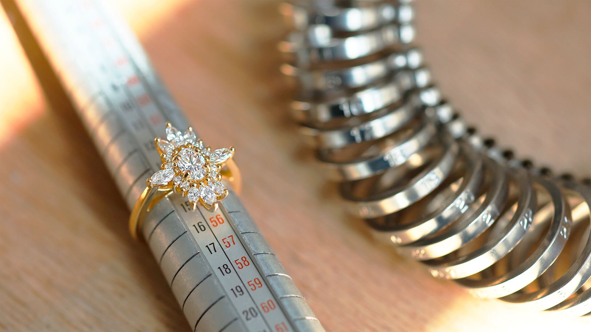 Bague posée sur un triboulet, avec un baguier à côté, illustrant les outils de mesure de taille de doigt utilisés par le joaillier lors de la création sur mesure.