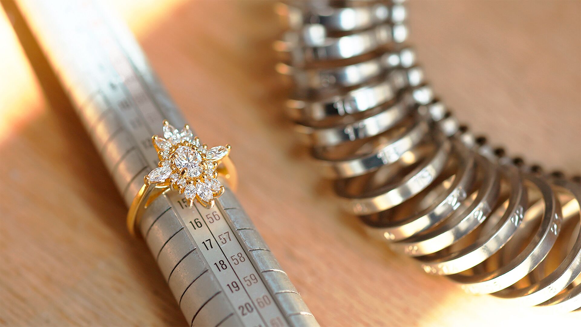 Bague posée sur un triboulet, avec un baguier à côté, illustrant les outils de mesure de taille de doigt utilisés par le joaillier lors de la création sur mesure.