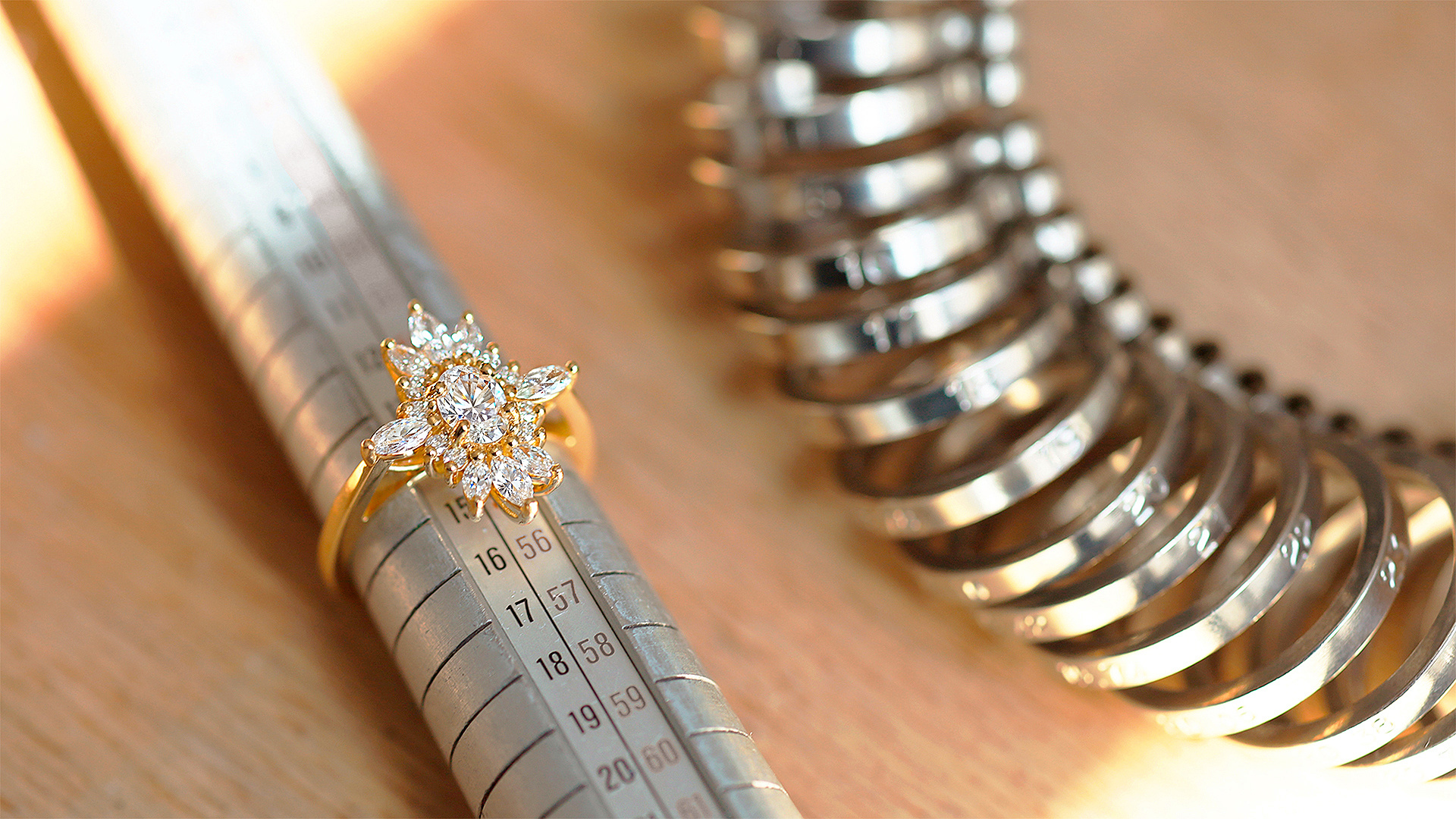 Bague posée sur un triboulet, avec un baguier à côté, illustrant les outils de mesure de taille de doigt utilisés par le joaillier lors de la création sur mesure.