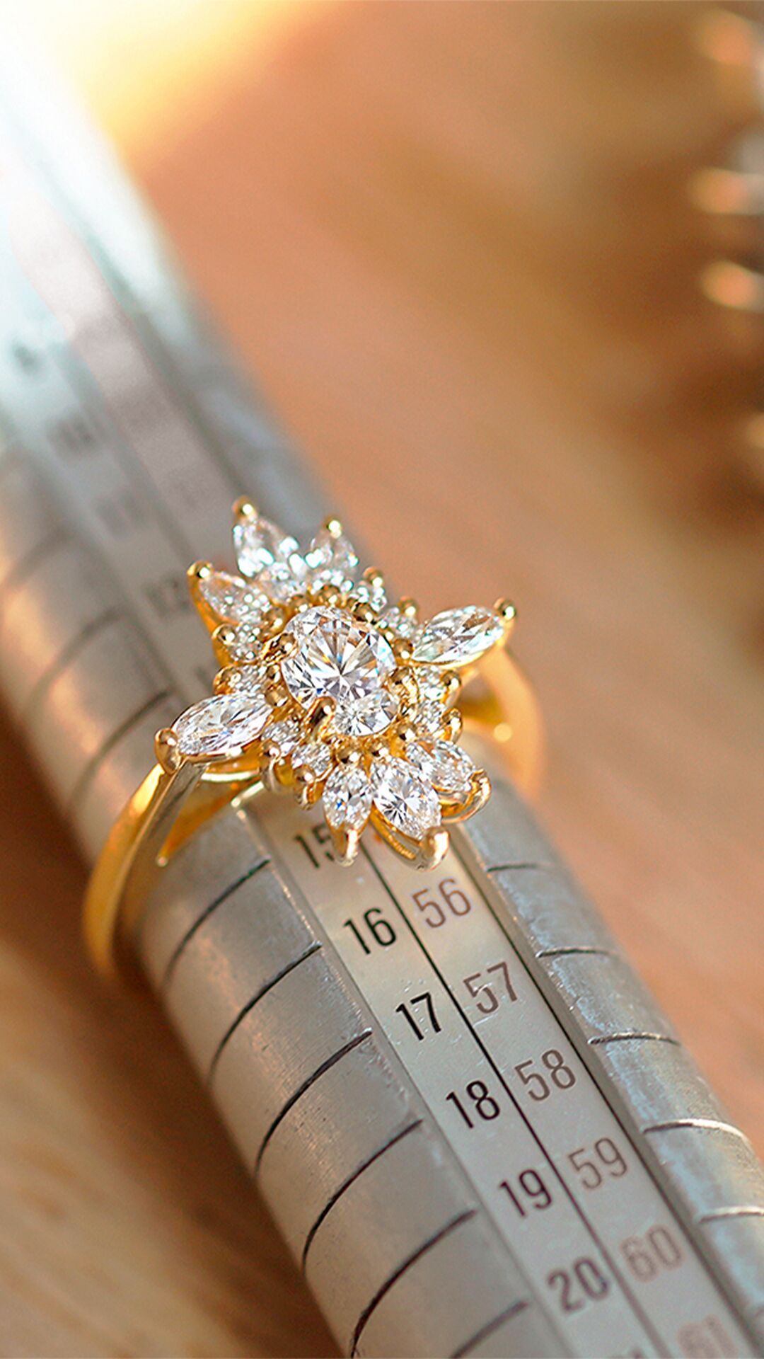 Bague posée sur un triboulet, avec un baguier à côté, illustrant les outils de mesure de taille de doigt utilisés par le joaillier lors de la création sur mesure.