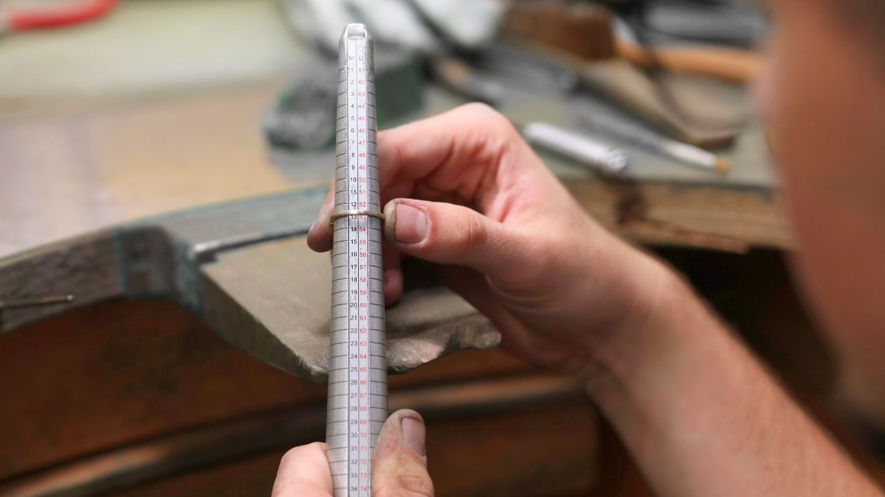 Joaillier mesurant la taille d’une bague sur un triboulet en atelier